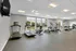 Modern fitness center with large windows, featuring state-of-the-art treadmills and elliptical machines under bright, sleek lighting.