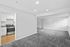 Modern, spacious apartment with a bright open living area, plush carpeting, and a sleek kitchen equipped with stainless steel appliances.