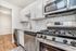 Modern kitchen with sleek stainless steel appliances, white cabinetry, and elegant tile backsplash.