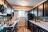 Modern kitchen featuring sleek dark cabinets, stainless steel appliances, and a stylish backsplash with ample countertop space.