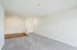 Bright, spacious living room at the Reserve at Sawmill with elegant carpet, hardwood floors, and white walls for modern living.