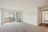 Bright, spacious living room with plush carpet and sliding doors to cozy balcony at the Reserve at Sawmill.