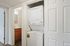Convenient laundry nook with modern stacked washer and dryer beside a sleek bathroom vanity.