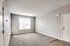 Bright and inviting living room with modern finishes, large window for natural light, and plush carpeting.