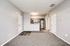 Inviting modern apartment interior with open kitchen, sleek stainless steel appliances, and cozy carpeted living area.