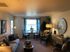 Cozy living room with elegant decor, featuring a plush sofa, stylish armchairs, and a charming dining nook by a sunlit window.