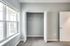Bright and inviting bedroom with plush carpet and spacious closet, enhanced by abundant natural light from large windows.