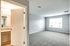 Bright and inviting bedroom with plush carpet, ample natural light, and a glimpse of a modern bathroom with elegant countertops.