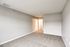 Spacious and bright bedroom with plush carpeting and neutral walls, featuring a walk-in closet for ample storage.