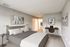 Cozy bedroom with modern decor, featuring a comfortable bed, stylish bedside tables, and a functional workspace with a sleek desk.