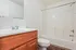 Bright and inviting bathroom featuring a sleek white vanity, elegant mirror, and a modern bathtub with shower.