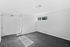 Bright and airy empty room with plush gray carpeting, white walls, and a window inviting natural light.