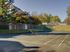 Exterior of a multi-story Twin Ridge Apartments building, featuring balconies for each unit and surrounded by trees.