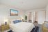 Elegant bedroom at the Reserve at Sawmill with plush upholstery, cozy carpet, vibrant art, walk-in closet, and modern ensuite.