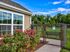 Charming outdoor view featuring vibrant pink flowers and a welcoming fenced pathway in a serene, lush environment.