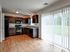 Inviting kitchen with elegant dark cabinetry, modern appliances, and bright natural light through large patio doors.