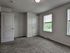 Bright and spacious bedroom with plush carpeting, large windows, and modern doors, creating a welcoming and comfortable atmosphere.