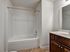Elegant bathroom with a pristine bathtub and sleek wooden vanity, perfect for relaxation.