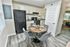 Chic apartment kitchen with modern cabinets, sleek black appliances, and cozy dining area set for four.
