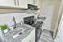 Modern kitchen with sleek granite countertops, stainless steel sink, and elegant cabinetry, creating a stylish cooking space.