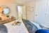Cozy bedroom with elegant decor, featuring a plush bed, a stylish wooden dresser, and modern accents that create a warm, inviting atmosphere.
