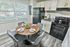 Chic apartment kitchen with modern cabinetry, sleek appliances, and a cozy dining area featuring a stylish round table and contemporary chairs.