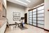 Modern fitness room with sleek exercise bike, elegant framed artwork, and frosted glass doors creating a serene workout ambiance.