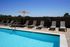 Chic outdoor pool area with inviting lounge chairs and bright umbrella, perfect for relaxation and leisure.
