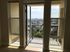 Bright apartment space showcasing a private balcony with stunning city views, perfect for relaxation and enjoying natural light.