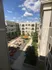 Charming courtyard view with cozy outdoor seating and lush green space surrounded by modern apartment buildings.