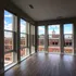 Bright apartment corner with expansive windows offering stunning city views, complemented by elegant wood flooring.