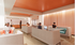 Modern lounge area with comfortable seating, vibrant orange ceiling accents, and people enjoying a relaxed atmosphere.