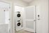 Modern apartment featuring a sleek in-unit laundry with a stacked washer and dryer enclosed in a stylish white closet.