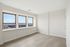 Bright, airy room featuring large windows with stunning city views, perfect for creating a serene living space.
