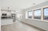 Bright modern kitchen with stainless steel appliances, sleek countertops, and expansive windows offering panoramic city views.