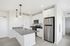 Sleek modern kitchen with stainless steel appliances, stylish pendant lighting, and elegant white cabinetry.