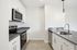 Modern kitchen with sleek white cabinetry, stainless steel appliances, and elegant countertops, providing a stylish and functional cooking space.