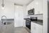 Modern kitchen with sleek stainless steel appliances, elegant white cabinetry, and a chic grey countertop.