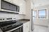 Modern kitchen with sleek stainless steel appliances, bright natural light, and elegant white cabinetry, offering stunning panoramic views.