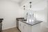 Modern kitchen with sleek countertops, stainless steel appliances, and large windows offering natural light.