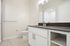 Sleek and contemporary bathroom with elegant fixtures, a large mirror, and ample storage space.