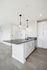Sleek modern kitchen with elegant gray countertops, stylish pendant lights, and built-in appliances for a contemporary living experience.