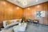 A modern lobby with sleek wood paneling and a cozy couch for a comfortable and stylish work environment at Model Tobacco Lofts.