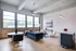 Model Tobacco Lofts living room with a comfy couch, a coffee table, and chairs for relaxation and gatherings.