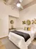 Model Tobacco Lofts bedroom with a comfy bed, a stylish dresser, a warm lamp, and a ceiling fan for a cool breeze.