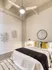 A cozy bedroom with a white bed and a ceiling fan, creating a serene and comfortable atmosphere at Model Tobacco Lofts.