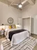 Bedroom interior with bed, nightstand, and ceiling fan at Model Tobacco Lofts.