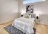Elegant bedroom design with white bed and classic black and white rug at Model Tobacco Lofts.