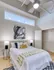 Stylish bedroom decor with white bed and trendy black and white rug at Model Tobacco Lofts.
