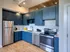 Model Tobacco kitchen with blue cabinets and stainless steel appliances. A modern and stylish cooking space.